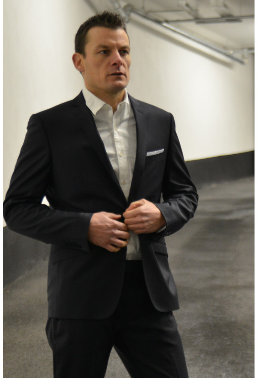 Homme portant la veste SULTAN noire. Elle comporte une poche poitrine et poches rabats.