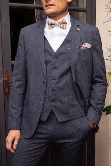 Homme portant le gilet  LYMAW bleu accompagné de sa veste et d'un nœuds papillon.