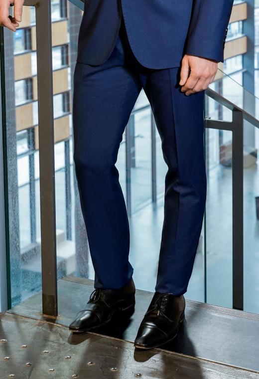 Homme portant le pantalon SULTAN bleu. Il comporte 2 poches avant et 2 poches arrière.