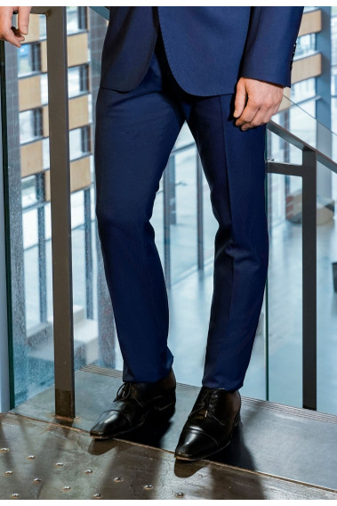 Homme portant le pantalon SULTAN bleu. Il comporte 2 poches avant et 2 poches arrière.