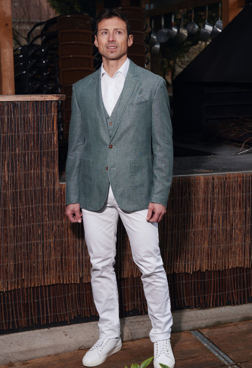 Homme portant la veste SAFARY verte. Elle comporte une poche poitrine et 2 poches plaquées.