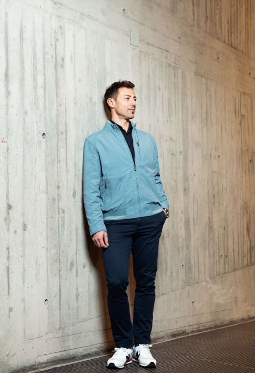 Homme portant le blouson  CLYDE bleu clair. Il comporte une poche poitrine et  2 poches repose mains.