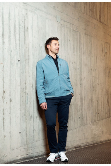 Homme portant le blouson  CLYDE bleu clair. Il comporte une poche poitrine et  2 poches repose mains.