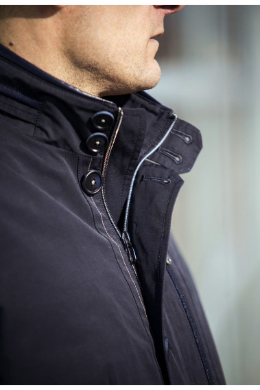 Zoom sur la parka KILIAN marine. Elle possède  une ouverture zippée contrastée sous patte boutonnée .