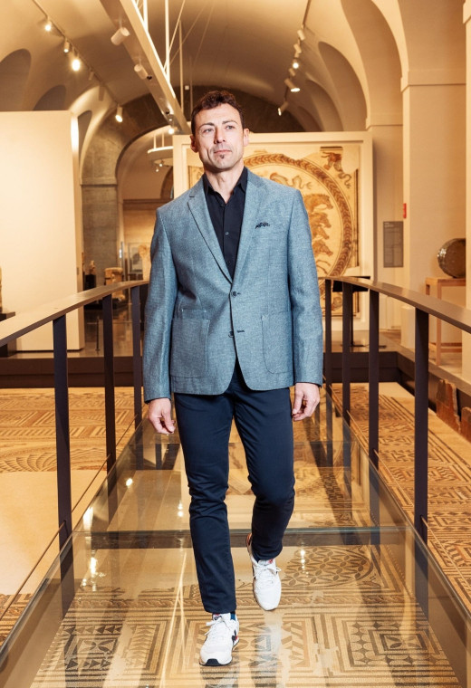 Homme portant la veste MILDA bleue. Elle comporte une poche poitrine et 2 poches plaquées.