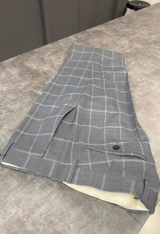 Homme portant le pantalon SULTAN à carreaux gris. Il comporte 2 poches avant et 2 poches arrière.