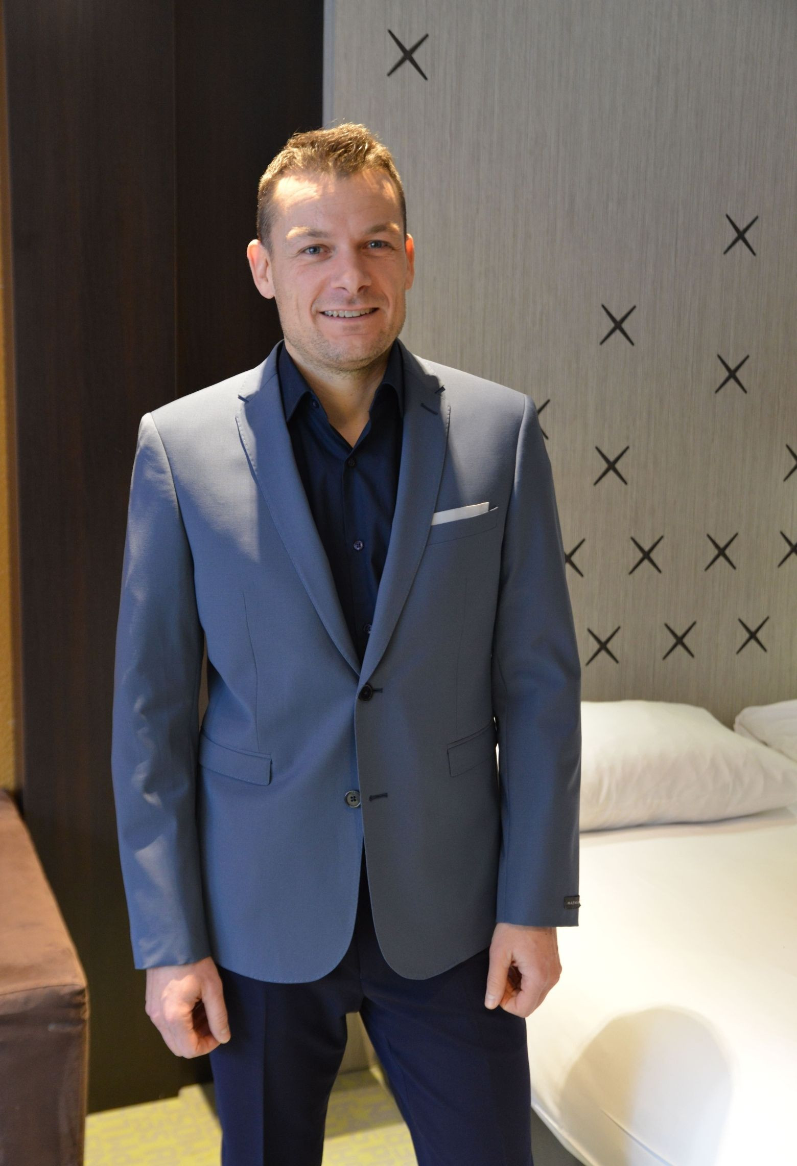 Homme portant la veste SULTAN gris bleuté. Elle comporte une poche poitrine et 2 poches rabats