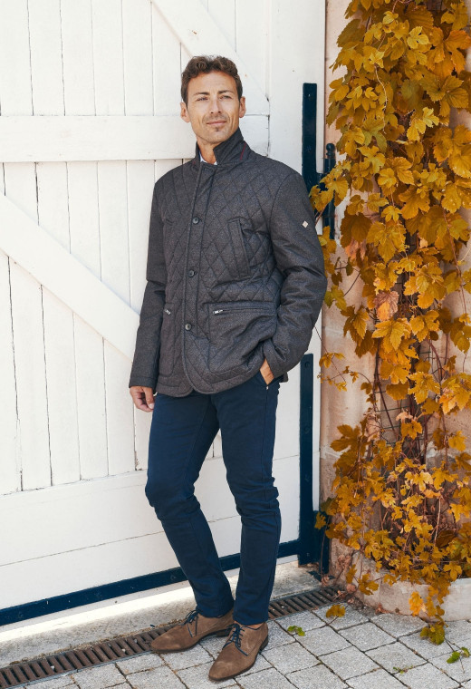 Homme portant la veste matelassée EKET marron chiné. Elle comporte 4 poches.