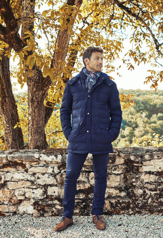 Homme portant la doudoune SKADIS marine. Elle comporte une poche poitrine et 2 poche à rabat.