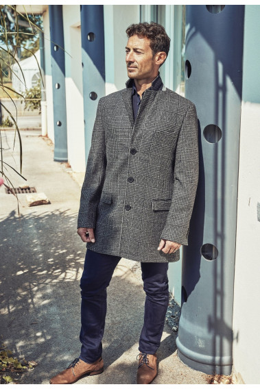 Homme portant le manteau SUAVE noir et gris. Il est long et comporte 3 poches.