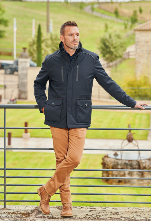 Homme portant la surveste ARTEMISA marine. Elle comporte 4 poches.