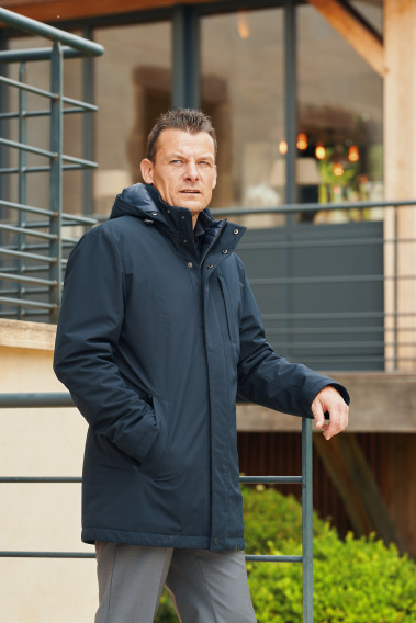 Homme portant la parka BESS marine. Elle comporte 3 poches.