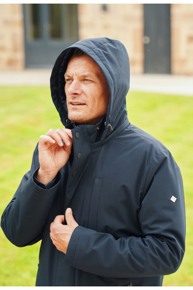 Homme portant la parka BESS marine  avec capuche.