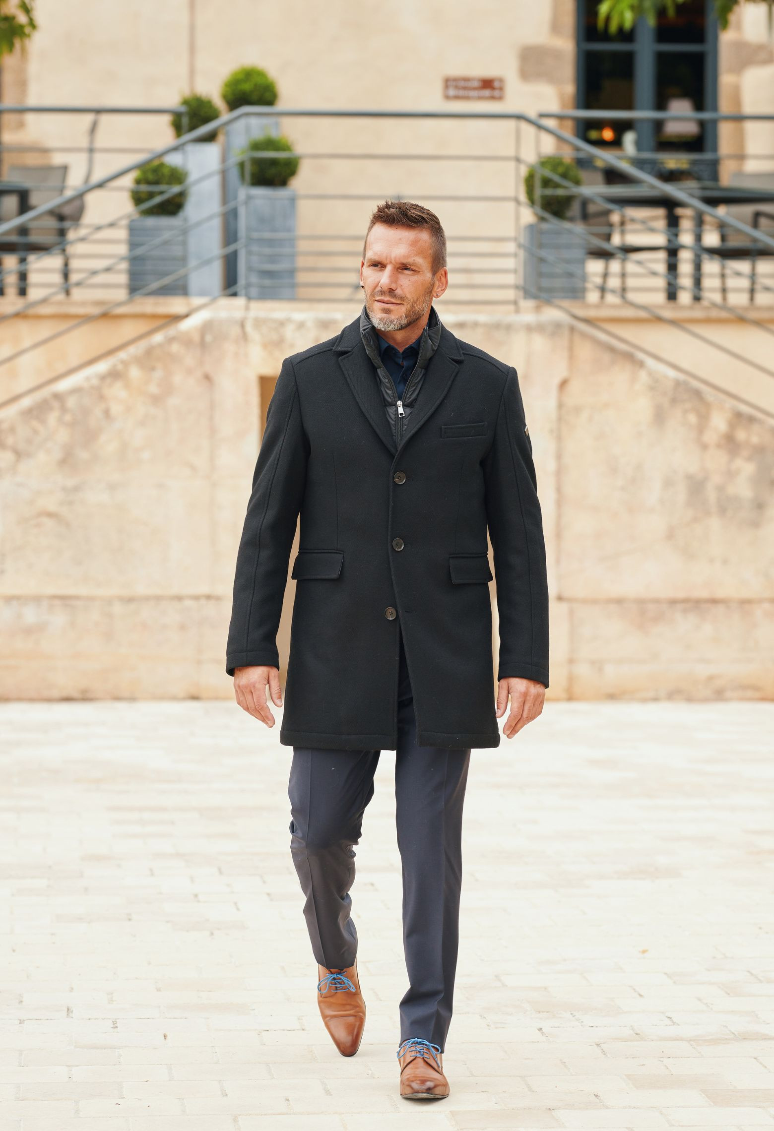 Homme portant le manteau EIFFEL noir. Il est long et comporte3 poches.