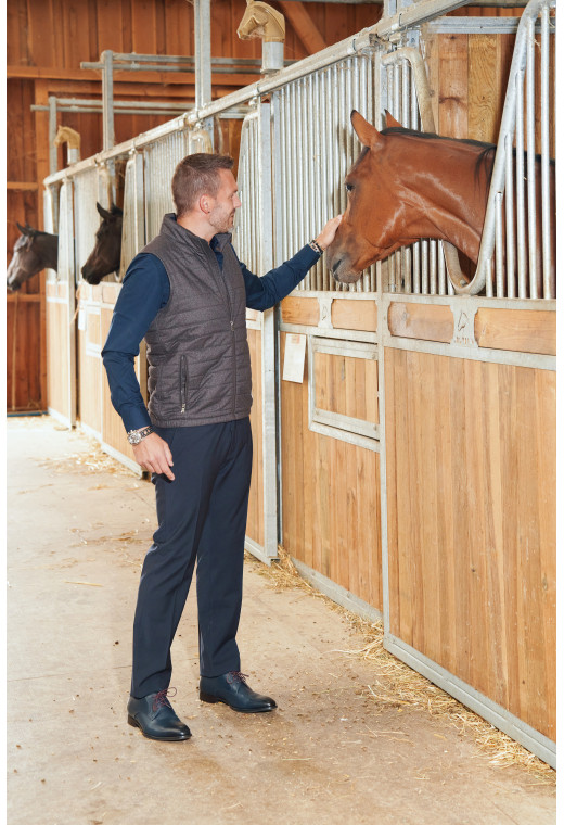 Homme portant la doudoune sans manche KOS marron. Elle comporte 2 poches repose mains.