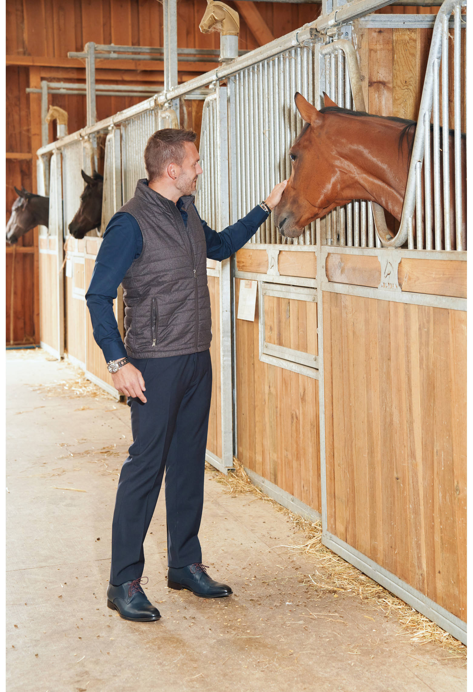 Homme portant la doudoune sans manche KOS marron. Elle comporte 2 poches repose mains.