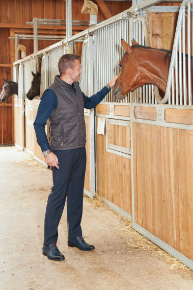 Homme portant la doudoune sans manche KOS marron. Elle comporte 2 poches repose mains.