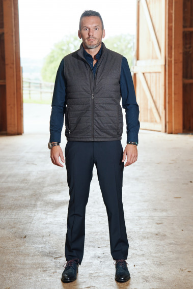 Homme portant la doudoune sans manche KOS marron. Elle comporte 2 poches repose mains.