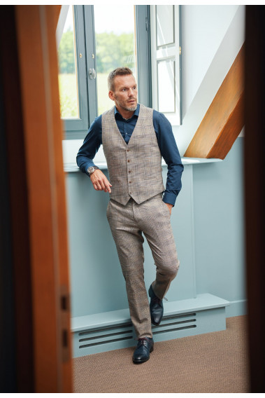 Homme portant le pantalon LINCOLN carreaux marron. Il comporte 3 poches avant et 2 poches arrière.