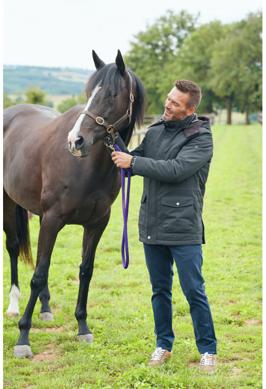 Homme portant la parka OCTAVIA kaki. Elle comporte 4 poches.