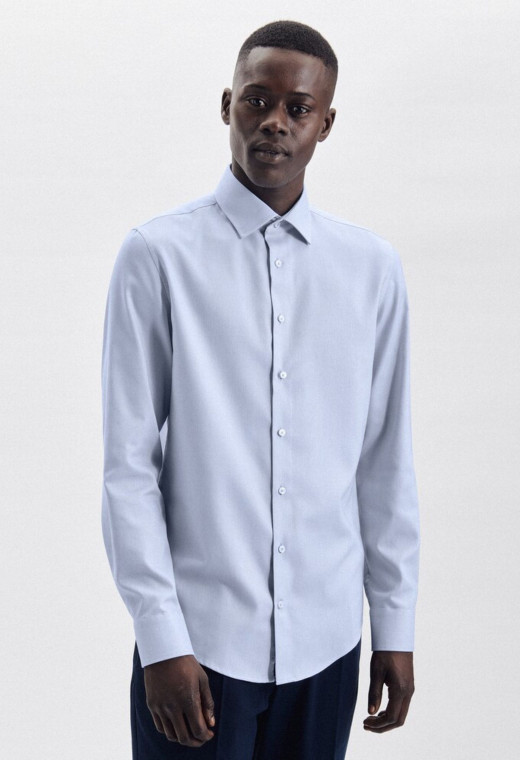 Homme portant la chemise slim armurée bleu. Elle est à manche longue.