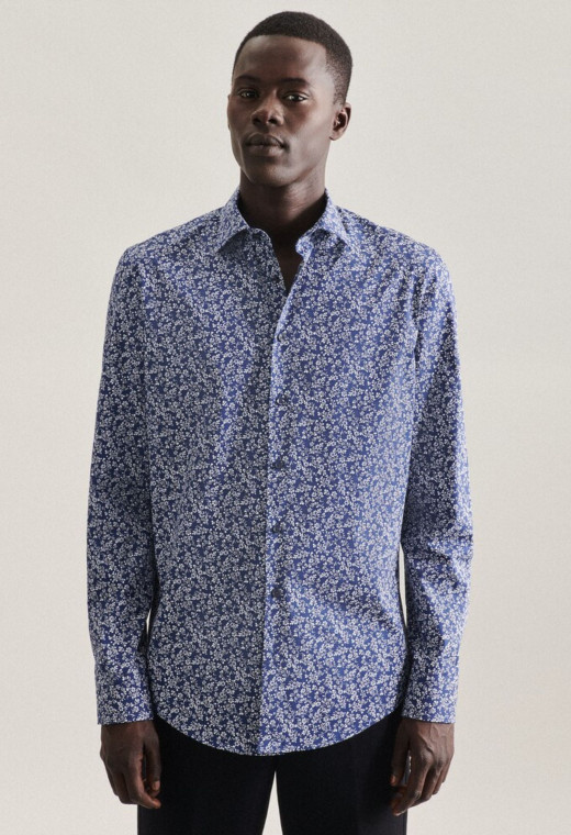 Homme portant la chemise slim liberty bleu. Elle est à manches longues et comporte des motifs florales.