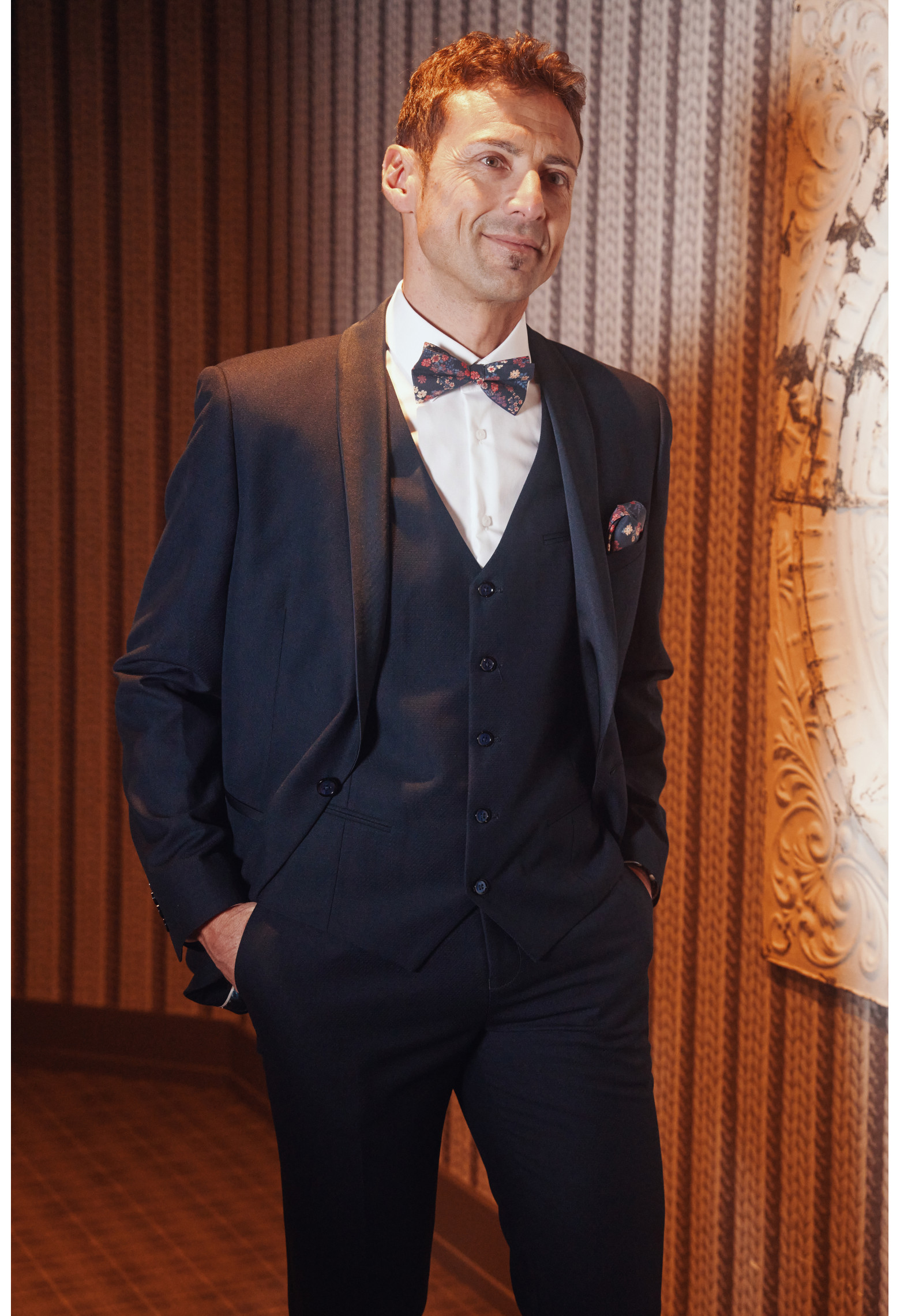 Homme de face en smoking CELESTEC couleur marine 3 pièces dans une maison.