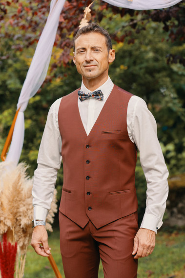 Homme portant le gilet CHRIS terracotta accompagné d'un nœuds papillon.
