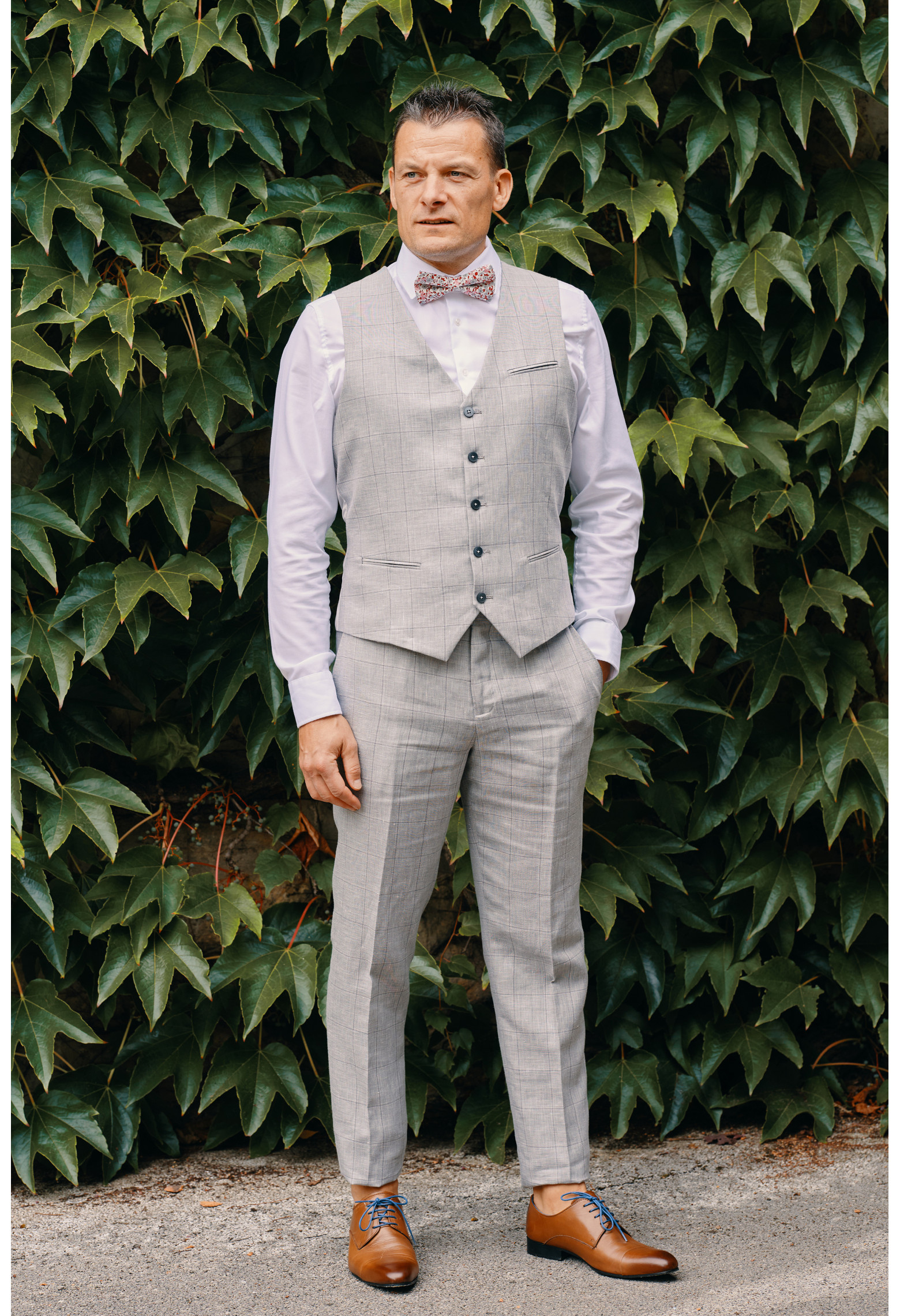 Homme portant le gilet  CHRIS gris à carreaux accompagné d'un nœuds papillon.