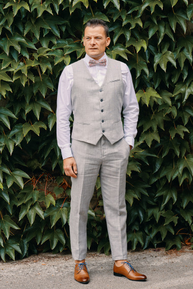 Homme portant le gilet  CHRIS gris à carreaux accompagné d'un nœuds papillon.