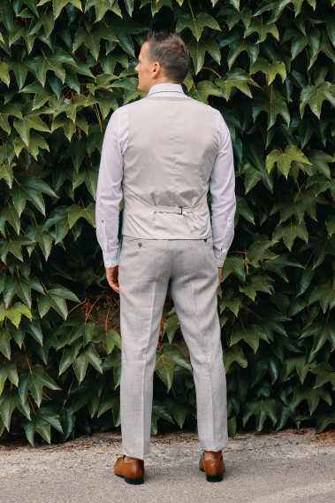 Homme de dos portant le  CHRIS gris à carreaux avec possibilité de le resserrer.