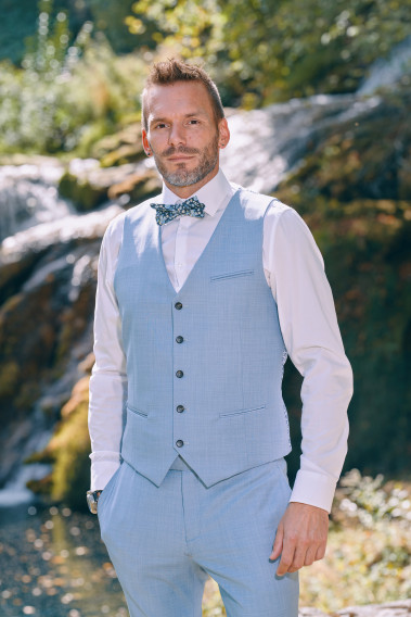 Homme portant le gilet CHRIS bleu pastel accompagné d'un nœuds papillon.
