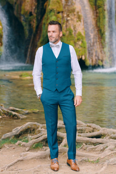 Homme portant le gilet CHRIS bleu-vert accompagné d'un nœuds papillon.