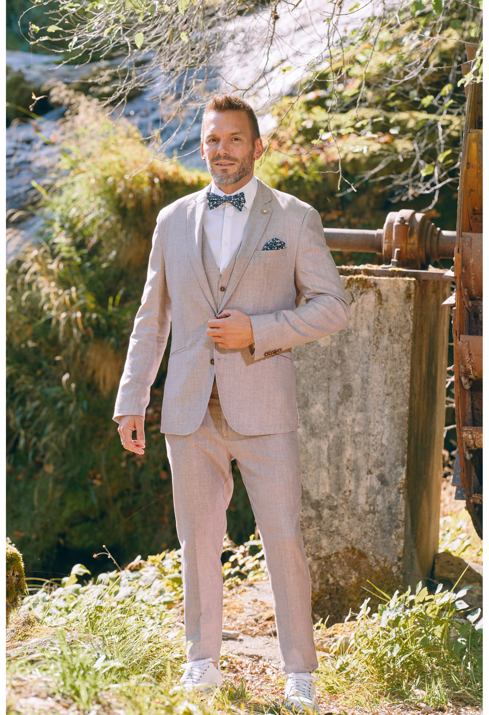Homme de face en costume GIORGIO couleur rose poudré 3 pièces dans une cours.