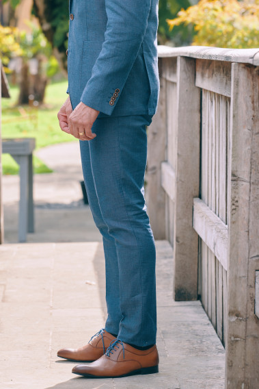 Homme de profil portant le pantalon LINCOLN bleu. Il comporte 3 poches avant et 2 poches arrière.