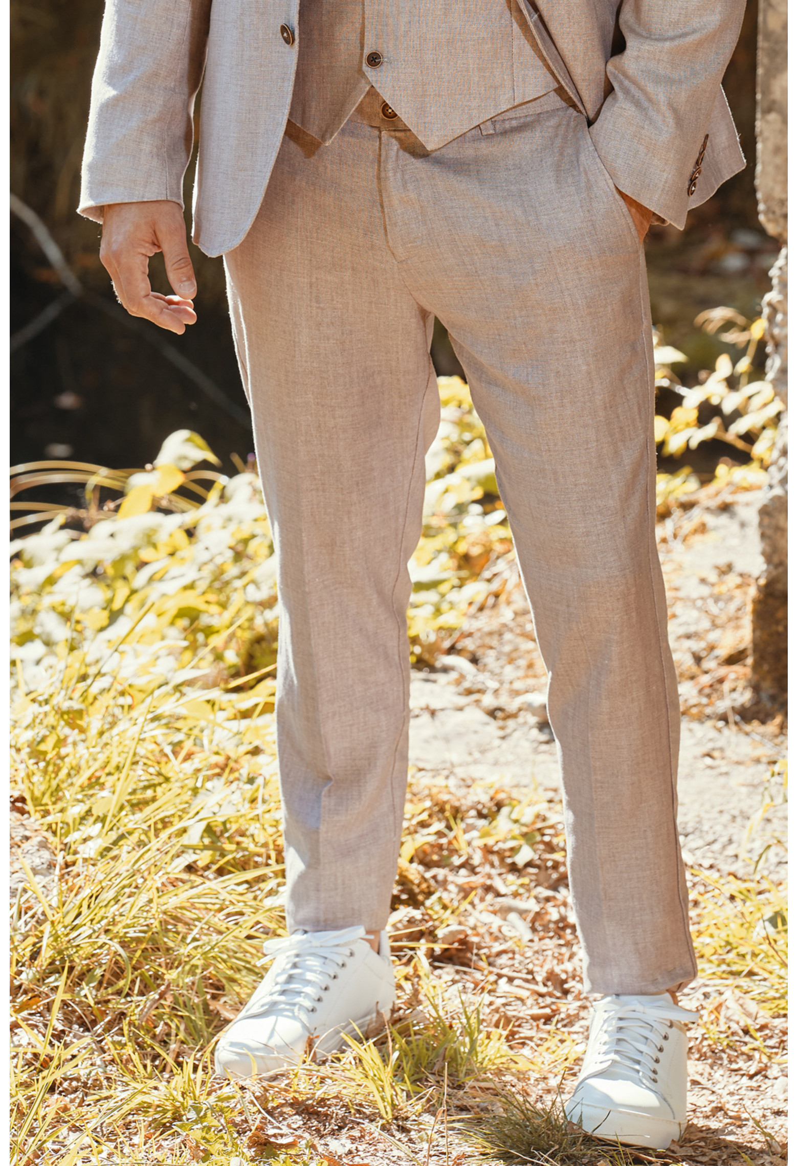 Homme portant le pantalon LINCOLN rose poudré. Il comporte 3 poches avant et 2 poches arrière.