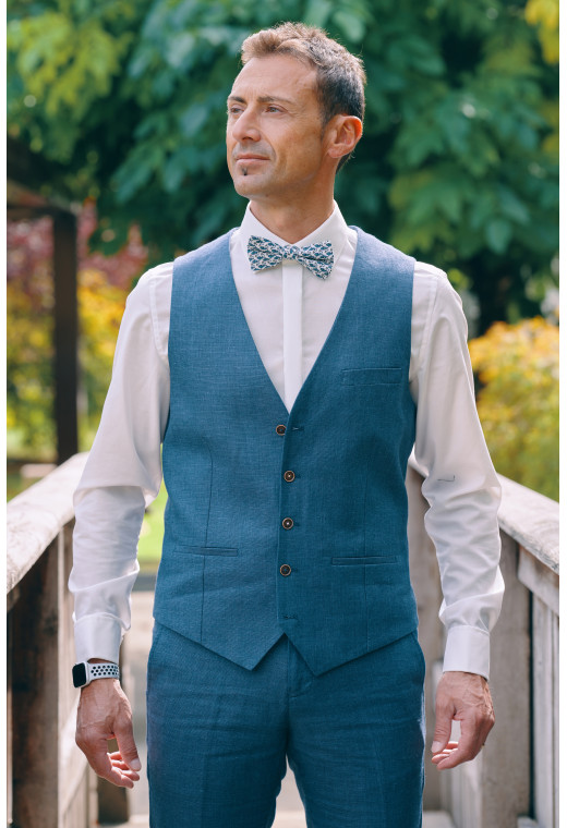 Homme portant le gilet LYMA bleu accompagné d'un nœuds papillon.