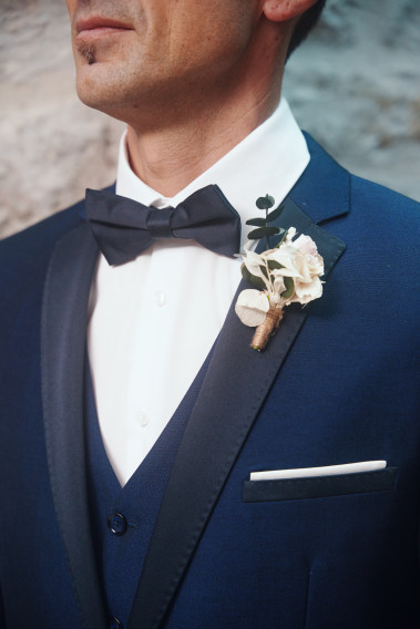 Costume SANTIAGO marine. Plan sur le nœuds  papillon noir et le pins bouquet de fleur.