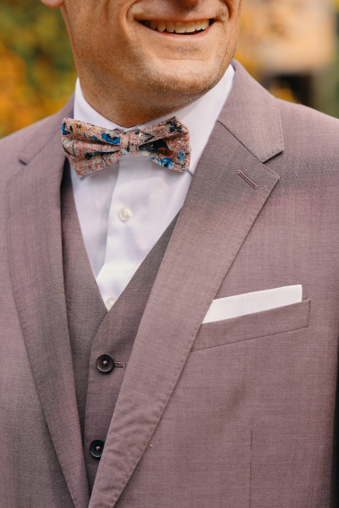 Costume SUAT rose-violet. Plan sur le nœuds  papillon à motif florale.