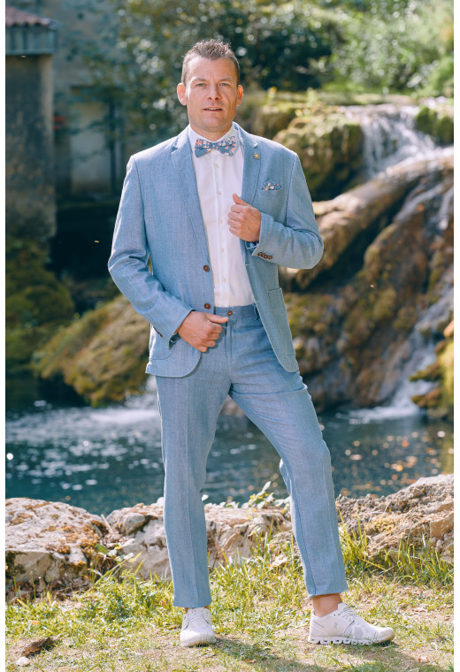 Homme portant la veste TROPICAL bleue. Elle comporte une poche poitrine et 2 poches plaquées.