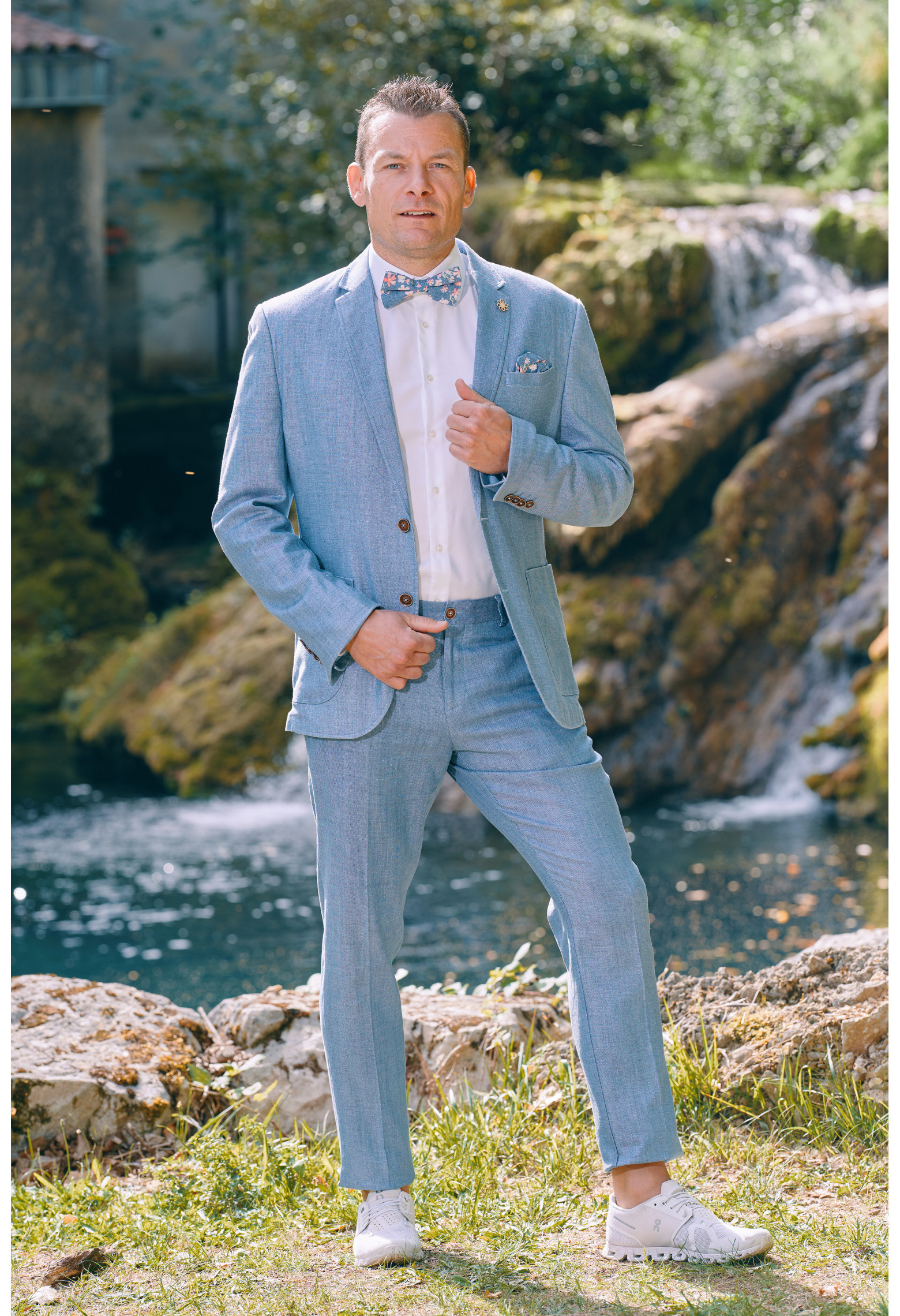 Homme portant la veste TROPICAL bleue. Elle comporte une poche poitrine et 2 poches plaquées.