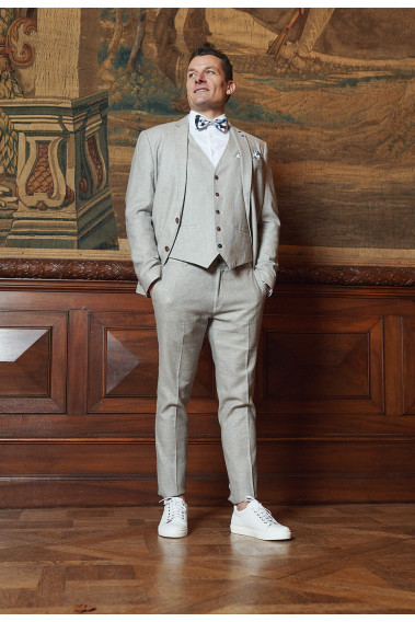 Homme portant la veste TROPICAL beige. Elle comporte une poche poitrine et 2 poches plaquées.