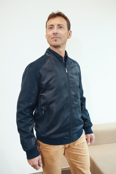 Homme portant le blouson OTHELLO suède marine. Il comporte 2 poches repose mains.