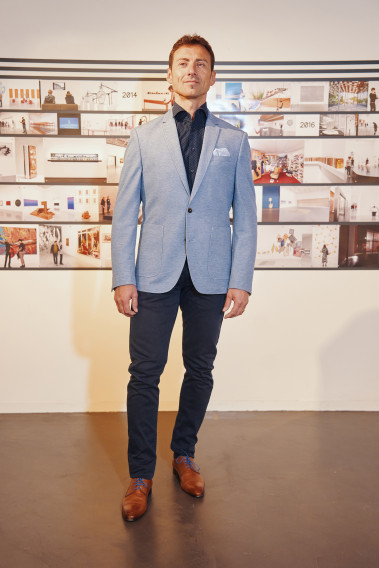 Homme portant la veste VALENTINA bleu clair. Elle comporte une poche poitrine et 2 poches plaquées.