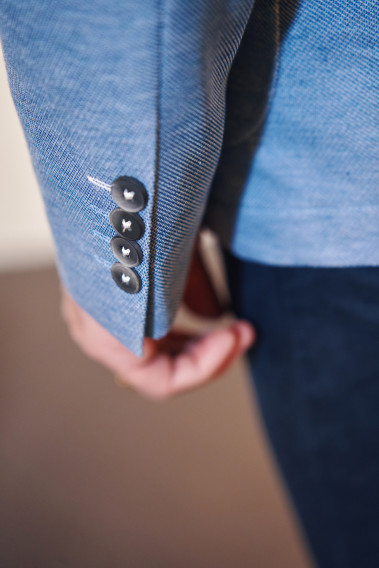 Zoom sur la manche de la veste VALENTINA bleu clair. Elle comporte 4 boutons.