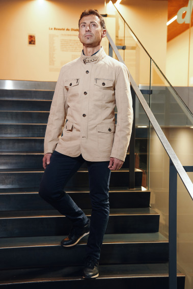 Homme portant la saharienne  VANILLA beige. Elle comporte 2 poches poitrine et 2 poches à rabat.