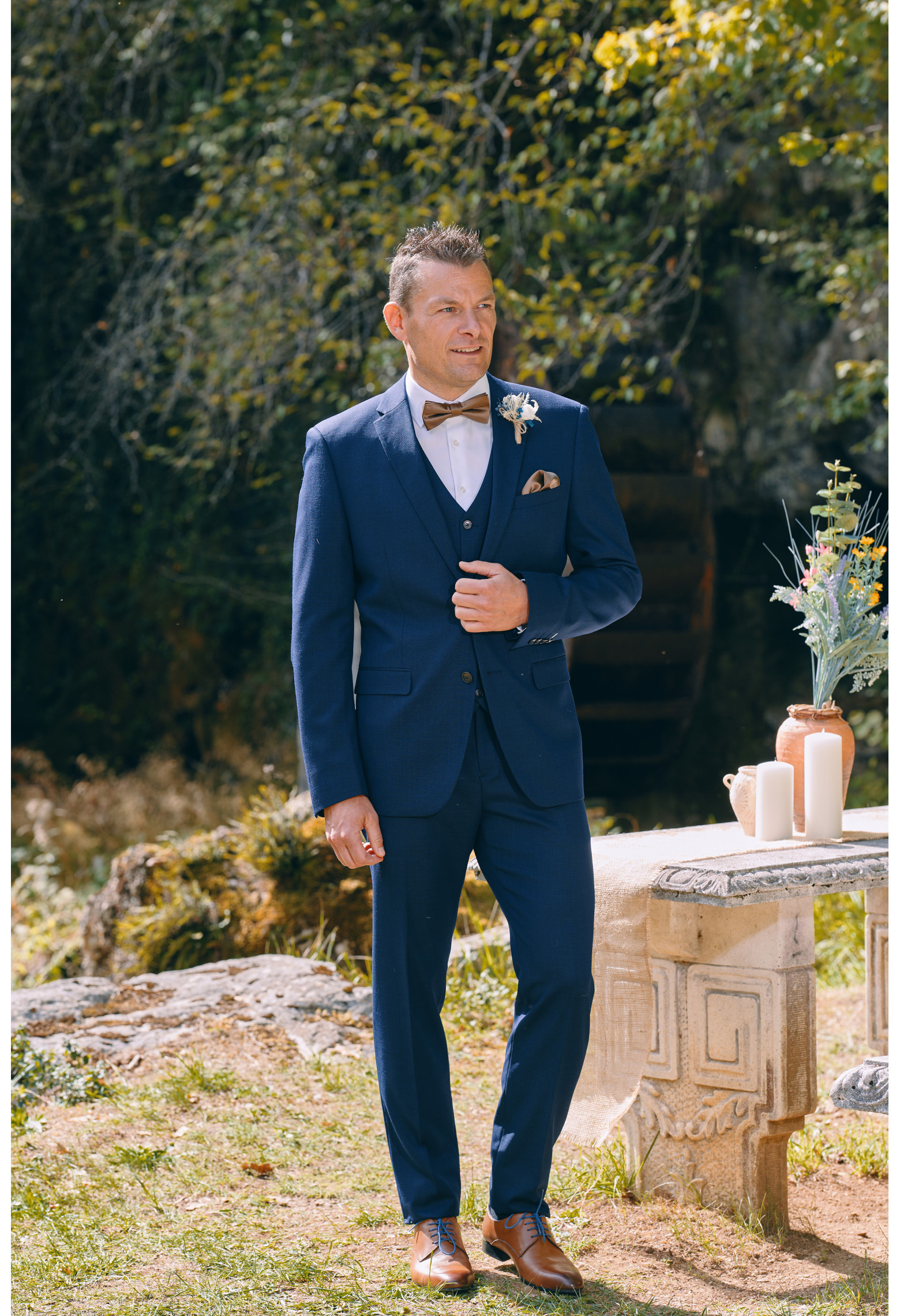 Homme de face en  Costume SUAT micro dessin couleur  marine 3 pièces devant une cascades.