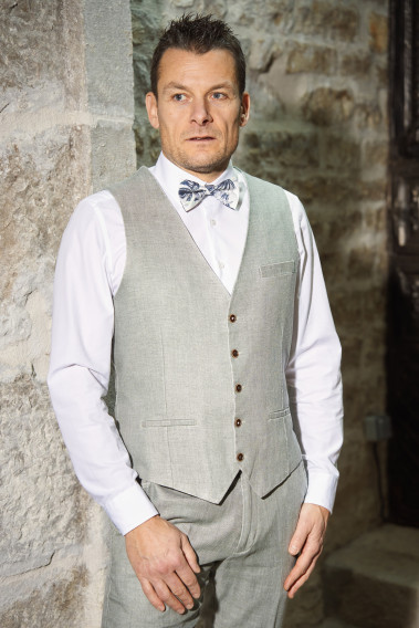 l'Homme porte le gilet du costume GIORGIO céladon à 5 boutons marrons.