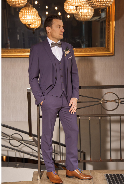 Homme de face en costume SUAT violet 3 pièces une cours. Il porte des chaussures marrons.