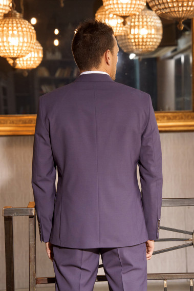 Homme de dos en costume SUAT violet 3 pièces une cours. Il porte des chaussures marrons.
